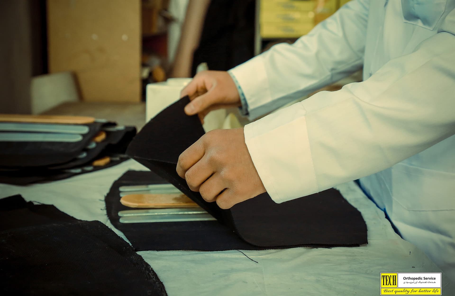 A technician assembling a fabric-and-metal back support by hand