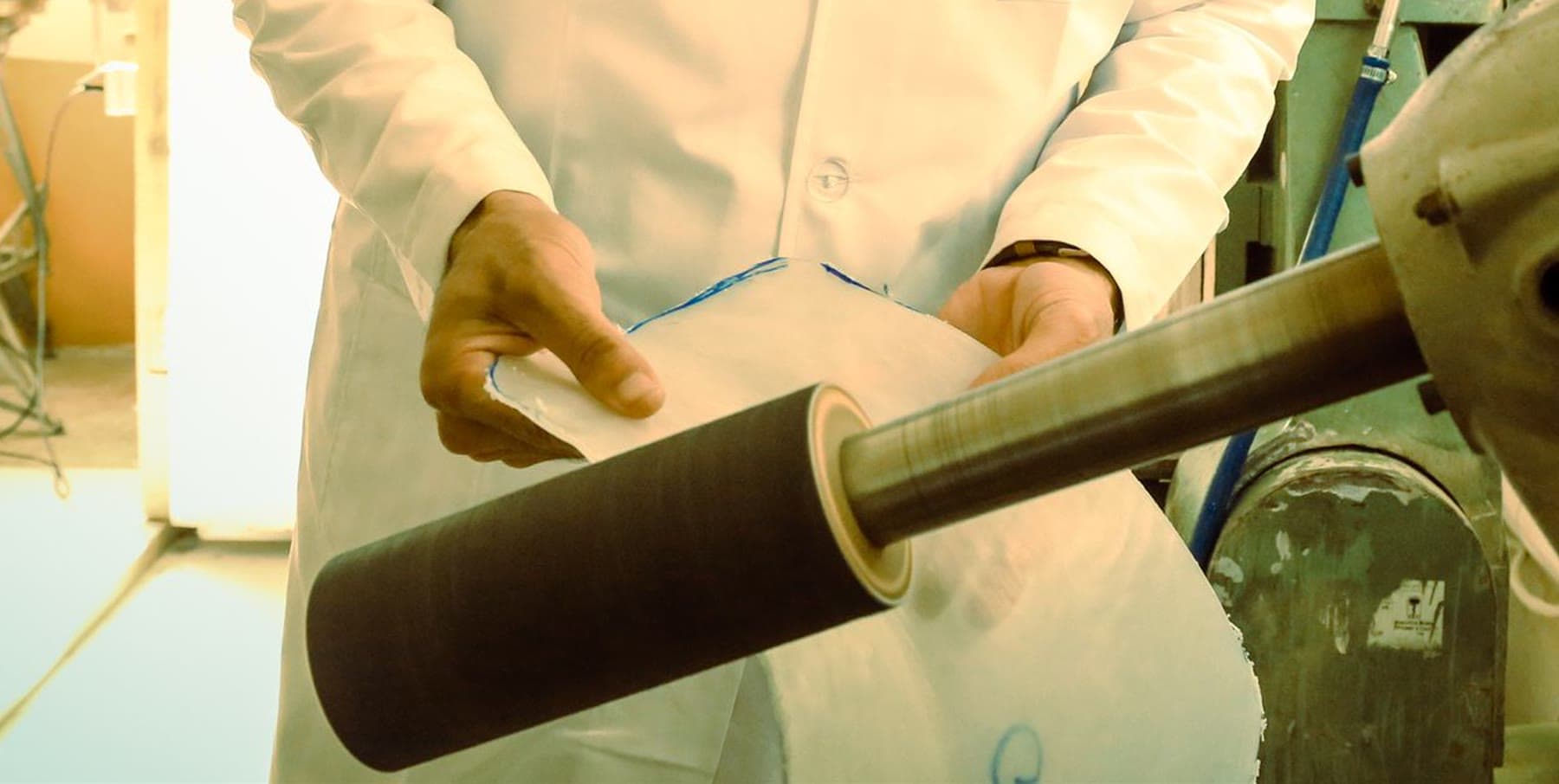 Close-up of a technician's hands finishing a prosthetic socket on the grinding machine